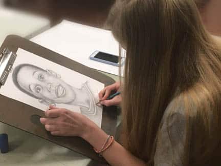 Teenager drawing a portrait in anrt class.