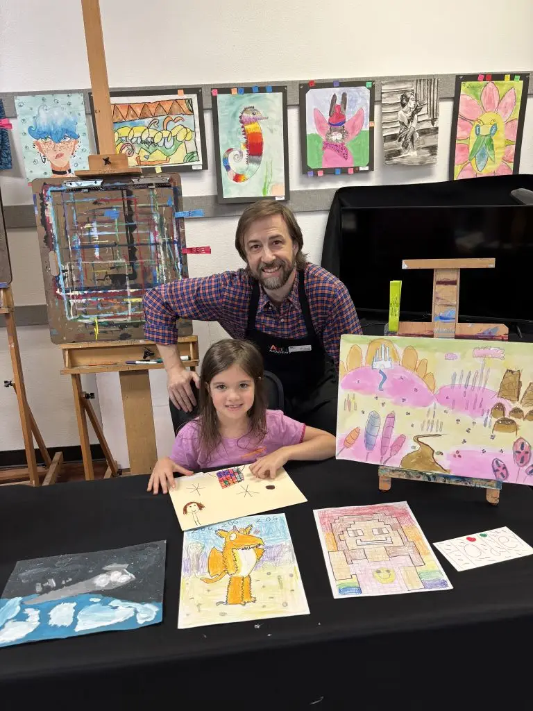 Mr. Jason and art student showcasing her artwork