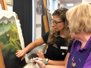 Art teacher guiding adult student on landscape painting during Art Class in Northwest