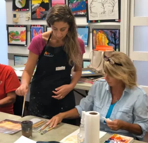 Art teacher explaining watercolor techniques to adult student during Art Class in Northwest Austin